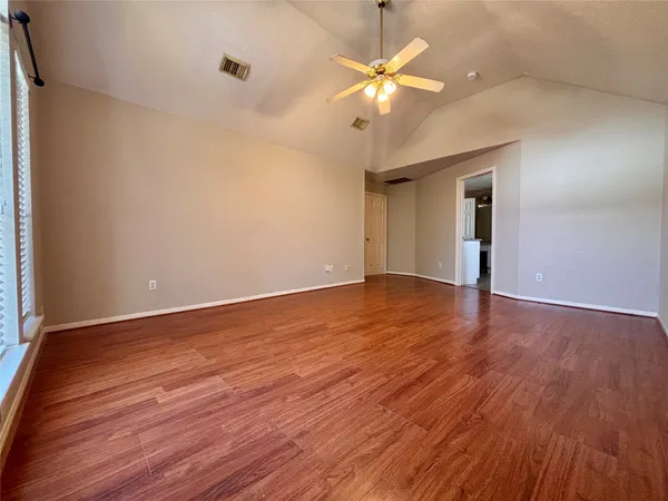 a view of an empty room with wooden floor