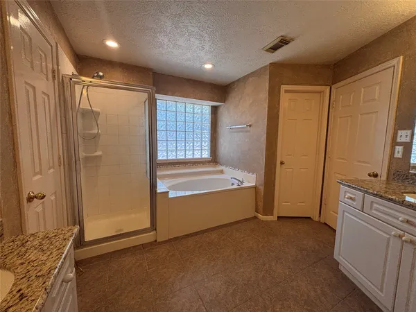 a bathroom with a tub shower and sink