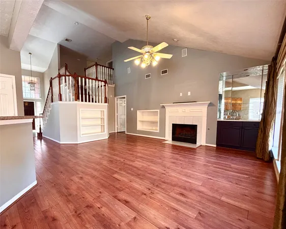 a view of a livingroom with a fireplace a chandelier and wooden floor