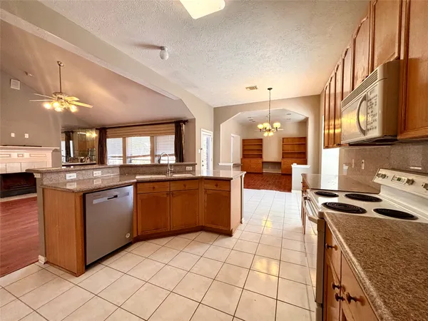 a kitchen with stainless steel appliances granite countertop a stove a sink dishwasher and a refrigerator