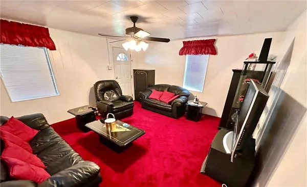 a living room with furniture a flat screen tv and a mirror