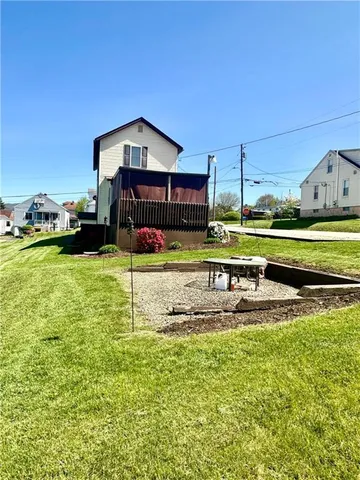 a view of a house with a yard and sitting area