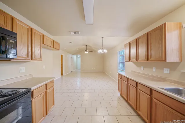 a large kitchen with stainless steel appliances granite countertop a sink and cabinets