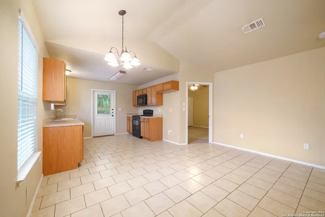 a view of a kitchen with furniture and refrigerator