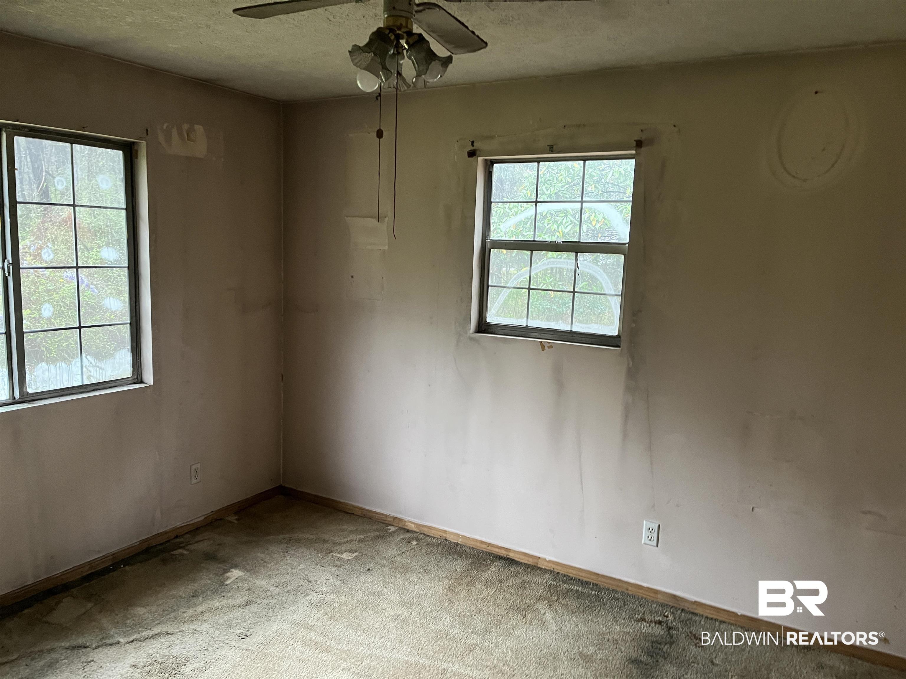 127 Moore Street Brewton, AL 36426 - Photo 13 of 15 Empty room with baseboards, carpet flooring, ceiling fan, and a textured ceiling