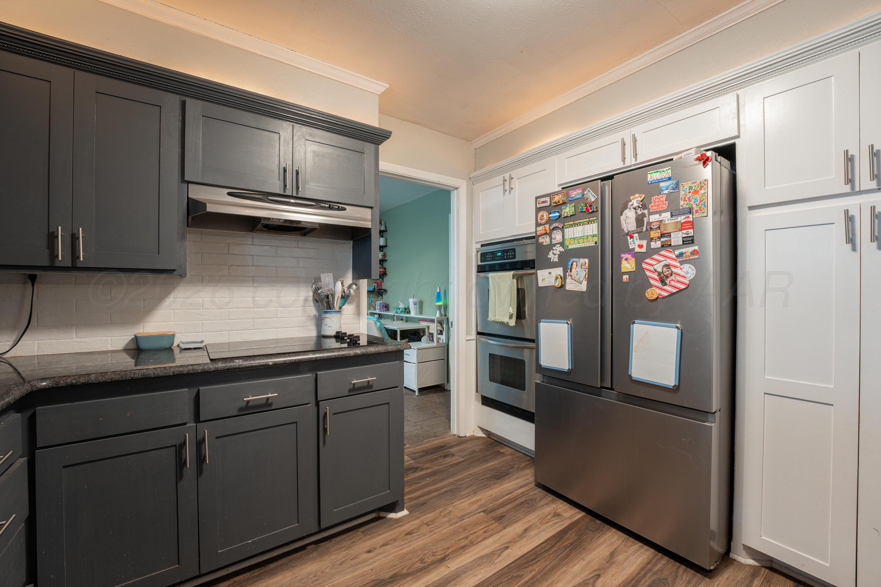 4836 Hillside Road Amarillo, TX 79109 - Photo 11 of 28 a kitchen with stainless steel appliances and refrigerator