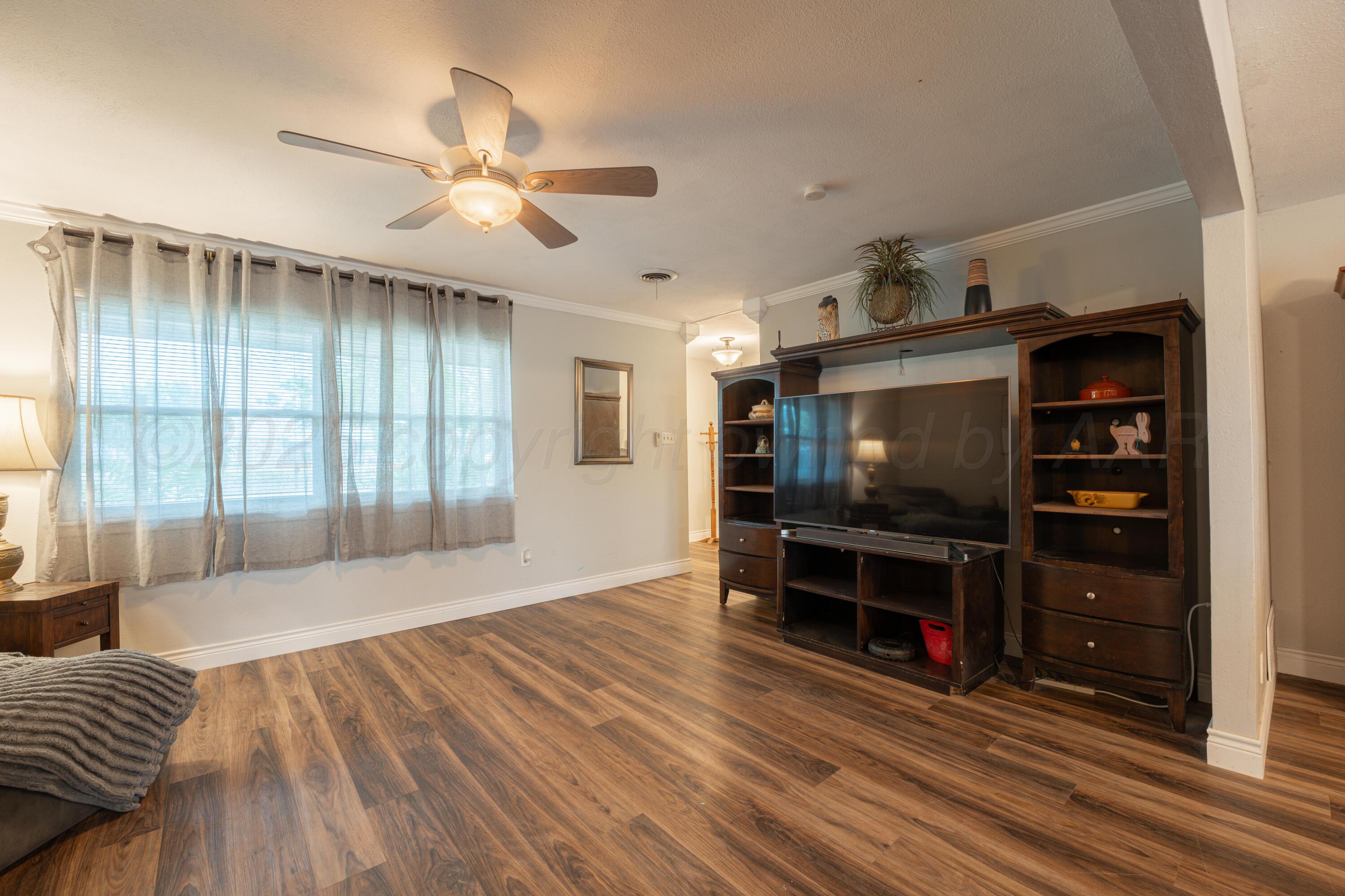 4836 Hillside Road Amarillo, TX 79109 - Photo 6 of 28 a living room with furniture and a flat screen tv