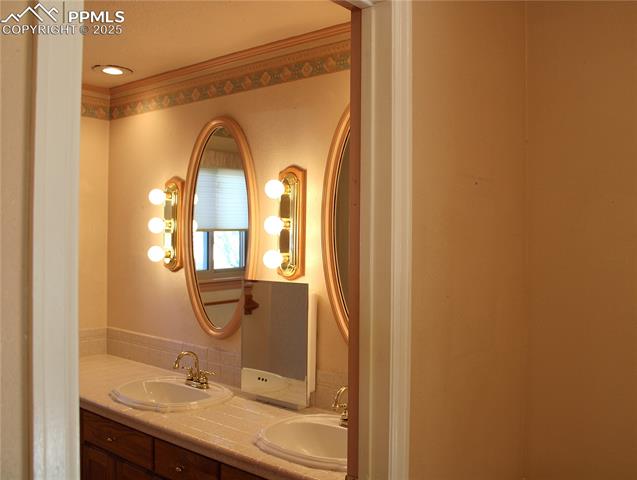 8340 Piute Road Colorado Springs, CO 80926 - Photo 26 of 48 Primary Bathroom with double vanity and crown molding