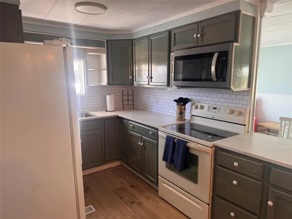 a kitchen with stainless steel appliances a stove microwave and sink