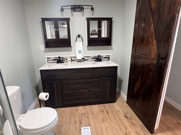 a bathroom with a toilet a sink and mirror