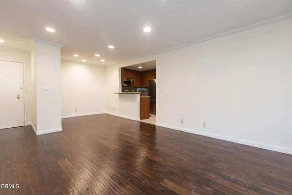 a view of empty room with wooden floor