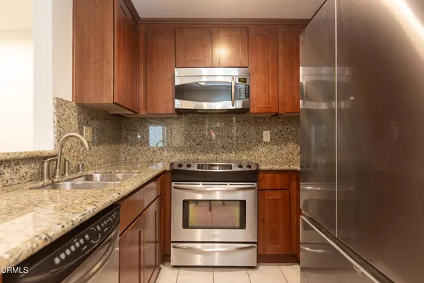 a kitchen with granite countertop a sink and a stove top oven
