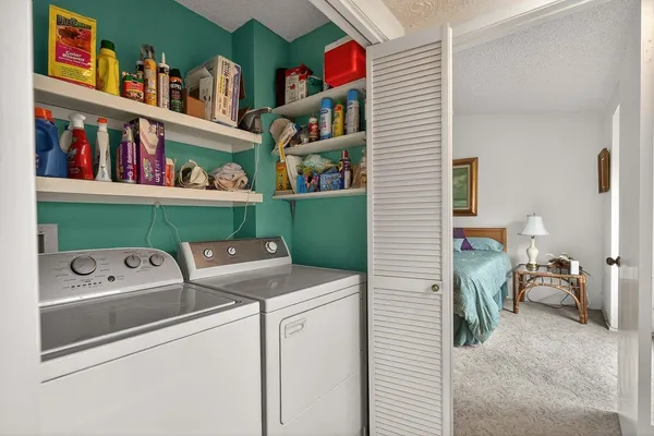 a utility room with dryer washer and shoe rack