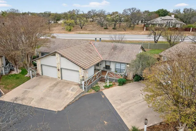 a view of a house with a yard and a large tree