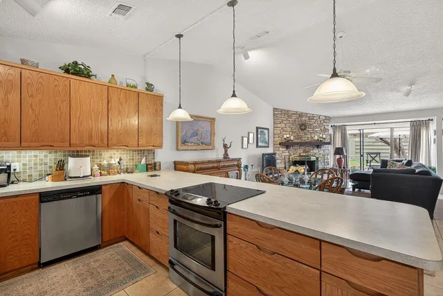 a kitchen with stainless steel appliances granite countertop a sink a stove and a wooden floors