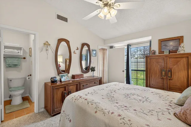 a bedroom with a bed a mirror on dresser and a chandelier