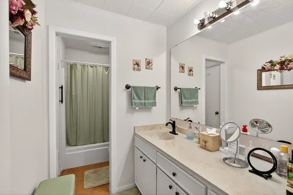 a bathroom with a granite countertop sink and a mirror