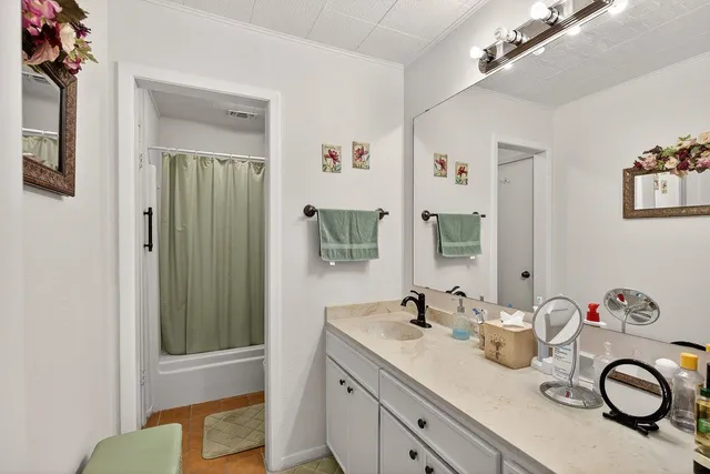 a bathroom with a granite countertop sink and a mirror