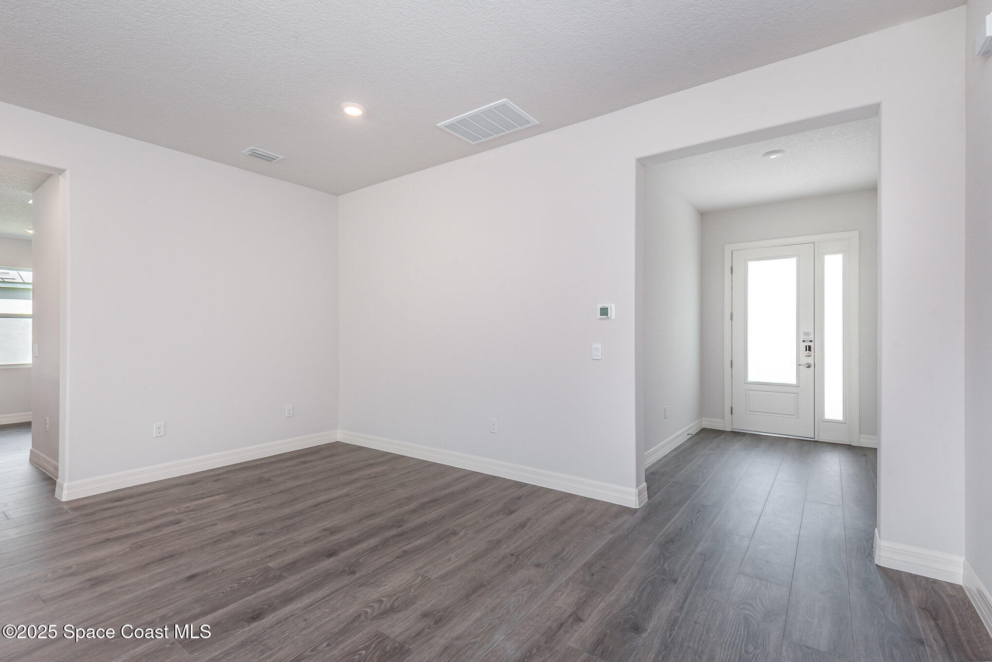 230 1st Street Cocoa, FL 32922 - Photo 5 of 34 wooden floor in an empty room with a window
