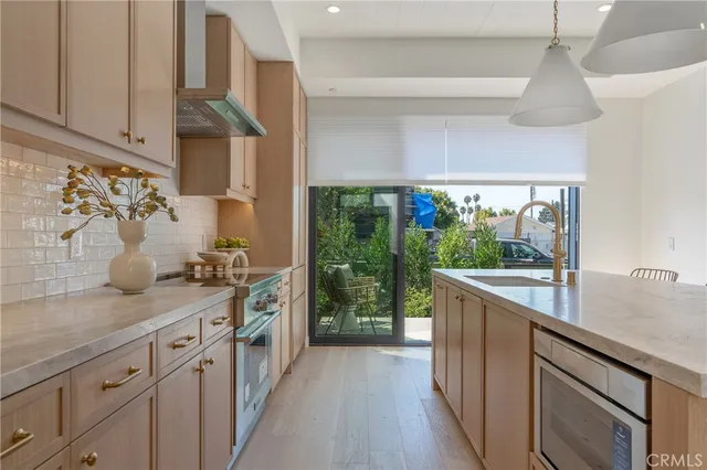 a kitchen with stainless steel appliances granite countertop a sink a stove and a wooden floors