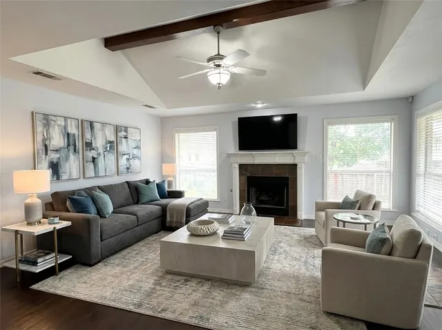 a living room with furniture a flat screen tv and a fireplace