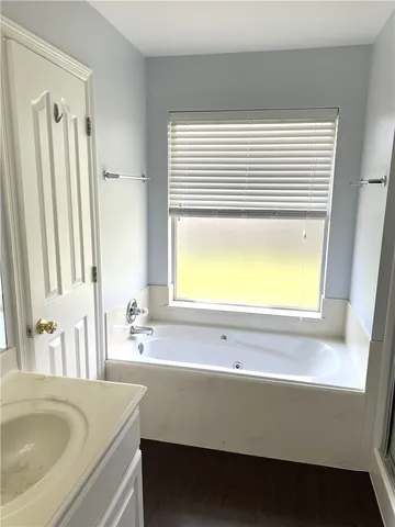 a bathroom with a sink a bathtub and a window