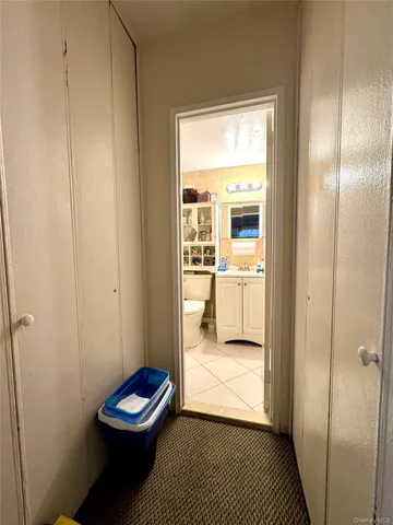 a bathroom with a granite countertop toilet a sink a mirror and a shower