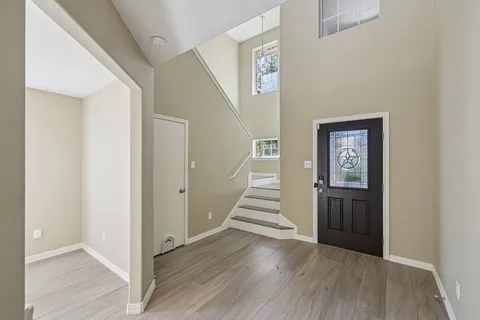 a view of a hallway with wooden floor and entryway
