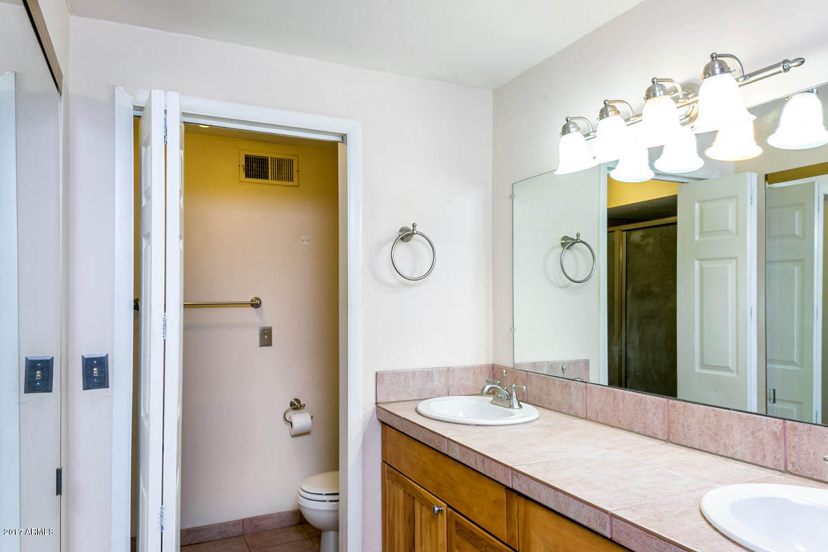 41568 North Rattlesnake Road San Tan Valley, AZ 85140 - Photo 17 of 32 a bathroom with a granite countertop sink a toilet and a mirror