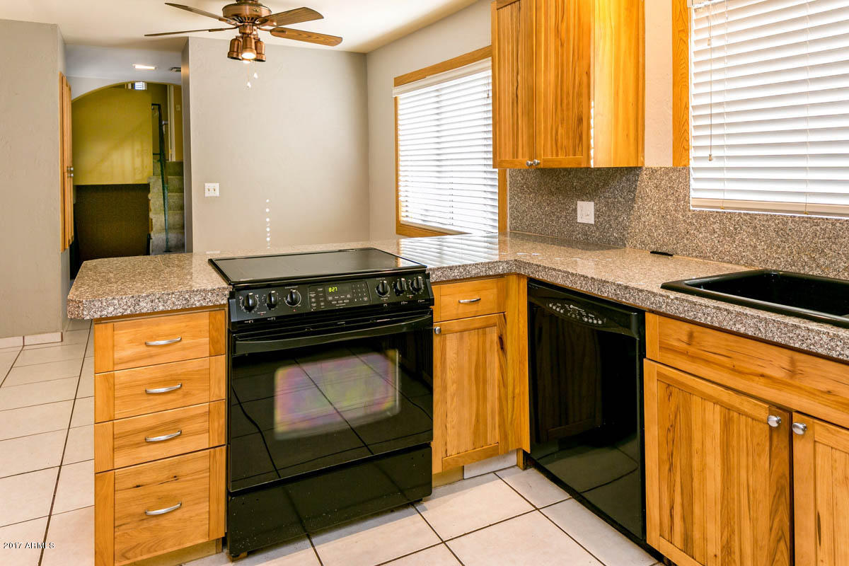 41568 North Rattlesnake Road San Tan Valley, AZ 85140 - Photo 4 of 32 a kitchen with stainless steel appliances granite countertop a stove a sink and a microwave