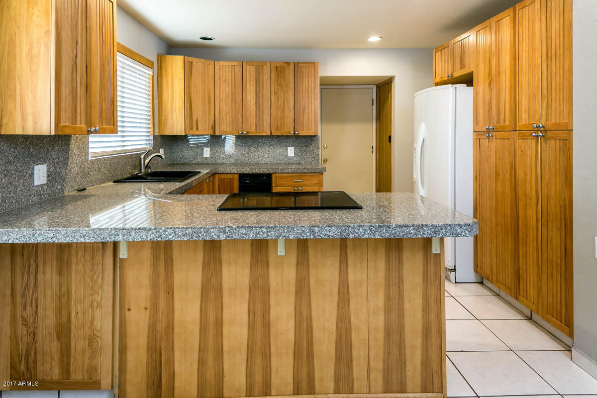 41568 North Rattlesnake Road San Tan Valley, AZ 85140 - Photo 5 of 32 a kitchen with stainless steel appliances granite countertop a refrigerator sink and cabinets