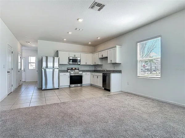 a large kitchen with cabinets and stainless steel appliances