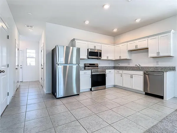 a kitchen with stainless steel appliances granite countertop a refrigerator sink and cabinets