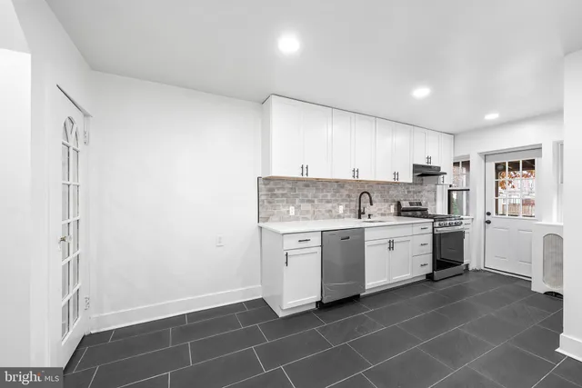 a large white kitchen with a sink