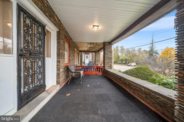 a view of an empty room with wooden floor fireplace and a window