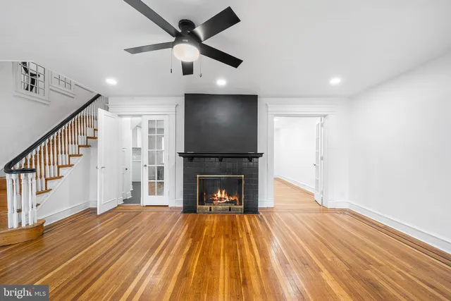 a view of a livingroom with wooden floor a fireplace and entryway
