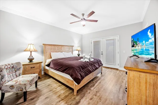 a bedroom with a bed and a dresser with wooden floor
