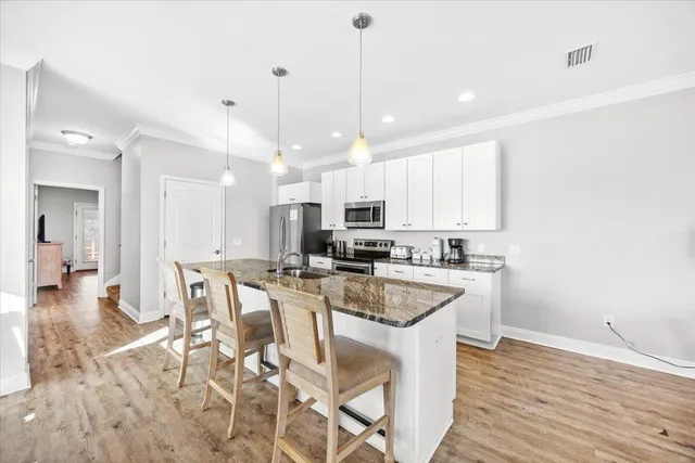 a bathroom with a granite countertop double vanity sink a mirror and a bathtub