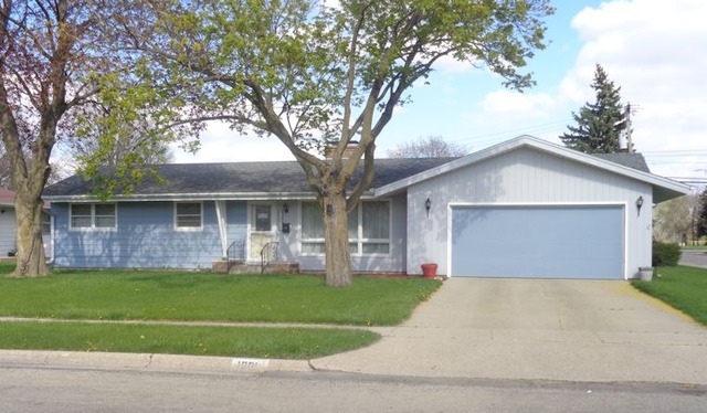 a front view of a house with a yard and a garage
