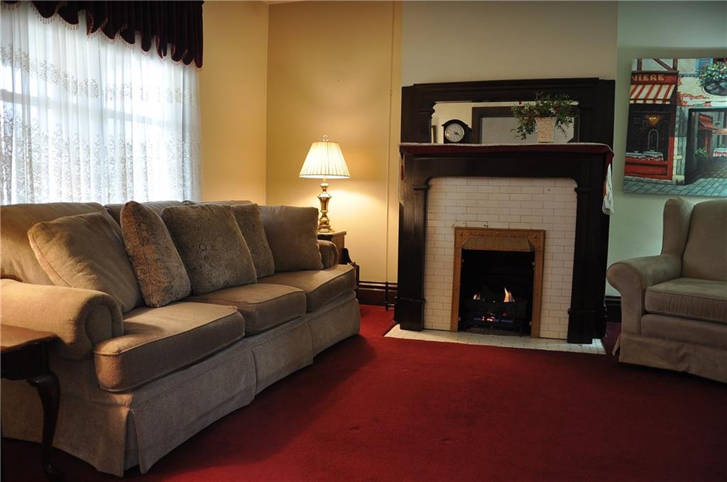 343 Roosevelt Road Pittsburgh, PA 15237 - Photo 9 of 25 Living room with gas burning fireplace, beautiful wood mantel that matches the original pocket doors leading into the living room connecting dining room.