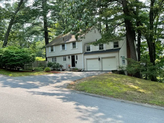 a front view of a house with a garden and trees