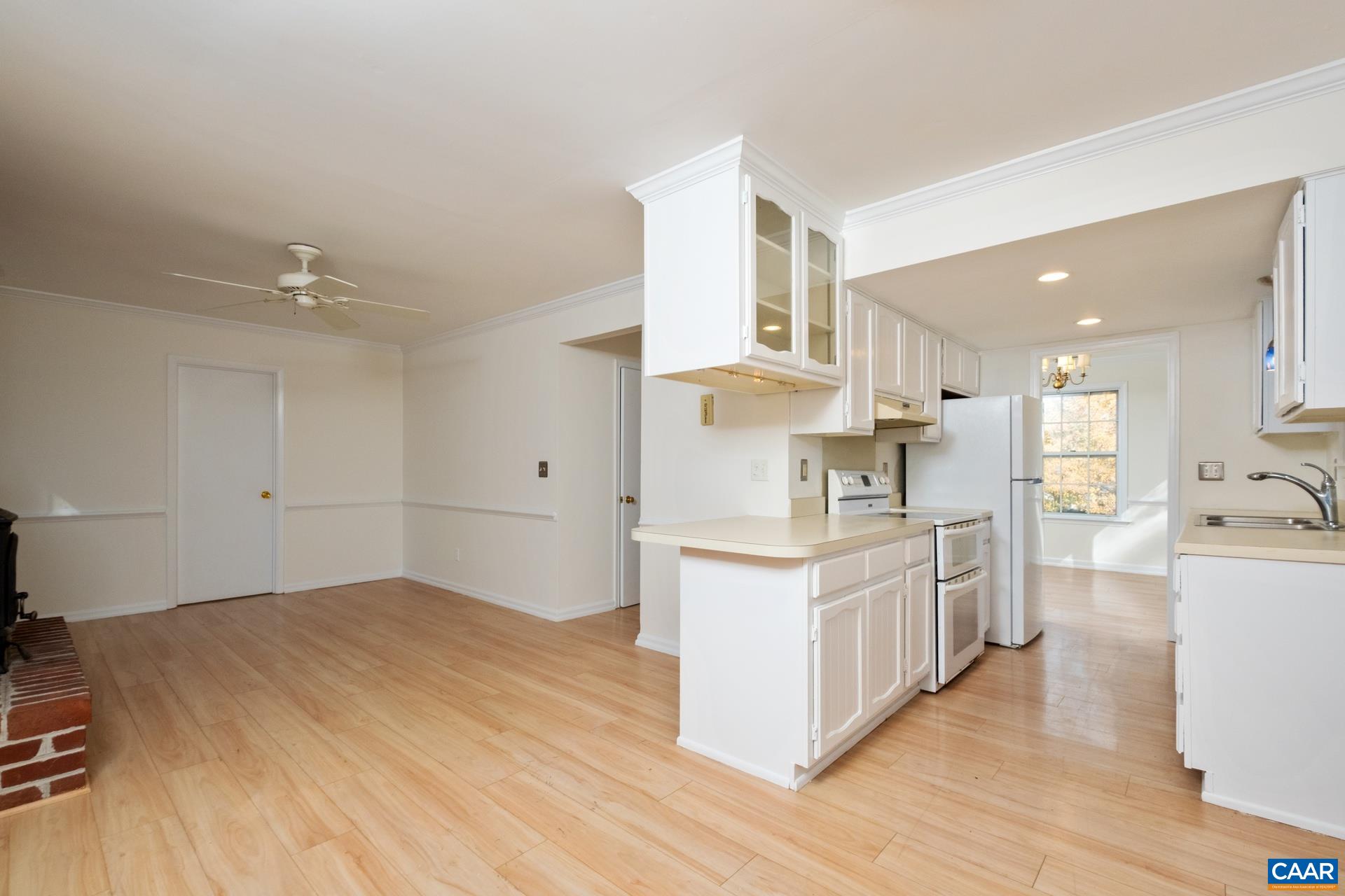1115 Cottonwood Road Charlottesville, VA 22901 - Photo 13 of 41 a kitchen with stainless steel appliances kitchen island wooden floors and white cabinets
