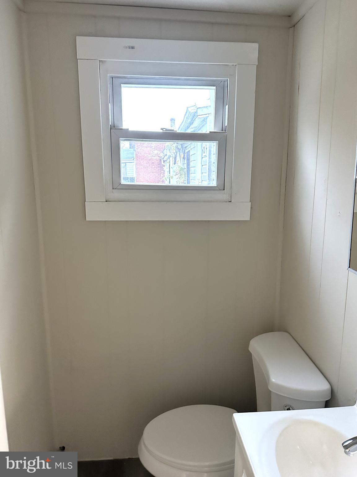 425 Highland Avenue, Unit A Chester, PA 19013 - Photo 13 of 24 a white toilet sitting in a bathroom next to a window