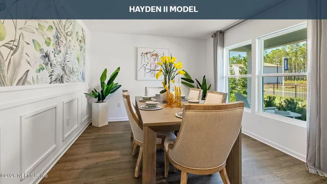 a kitchen with stainless steel appliances granite countertop a table chairs stove and wooden floor