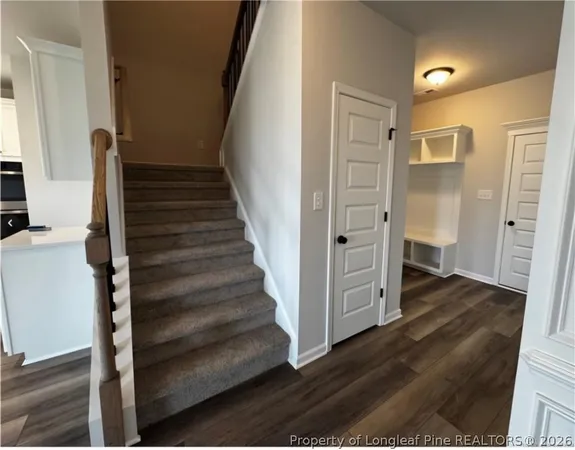 a view of a hallway with wooden floor and entryway