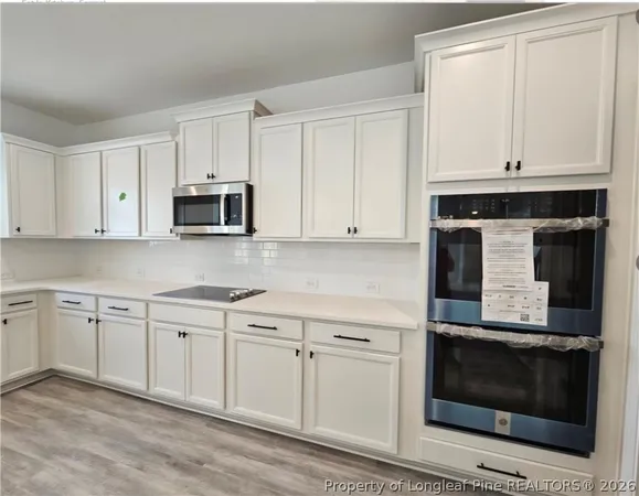 a kitchen with white cabinets and appliances