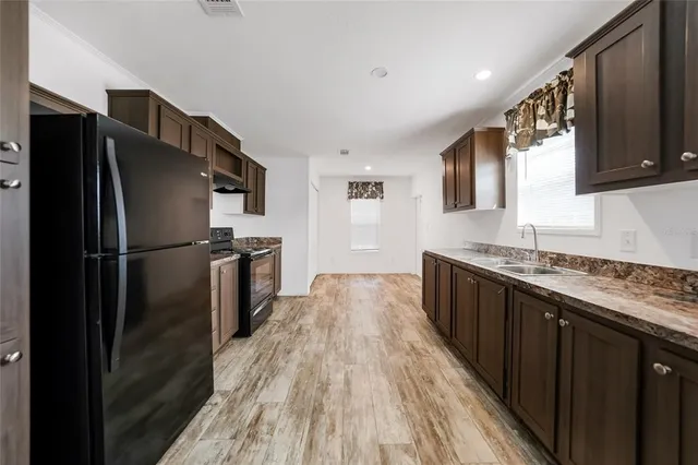 a view of an empty room with a kitchen and a window
