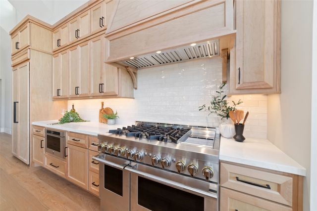 a kitchen with granite countertop stainless steel appliances and white cabinets