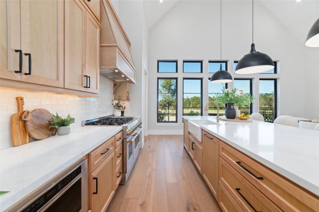 a kitchen with kitchen island granite countertop a sink a counter top space and stainless steel appliances