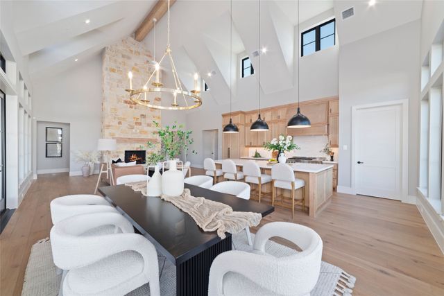 a living room with lots of furniture kitchen view and a chandelier